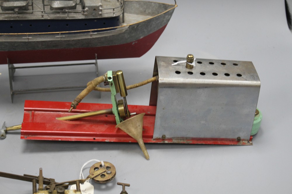 A 1950s Mamod ME1 clockwork steam engine, a Vane gear for a pond yacht and a modern painted metal model of a boat